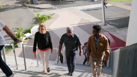 Louis Mapou, Catherine Ris, présidente de l’Université de Nouvelle-Calédonie et un étudiant géographe montent les marches qui conduisent à l’amphithéâtre 80.